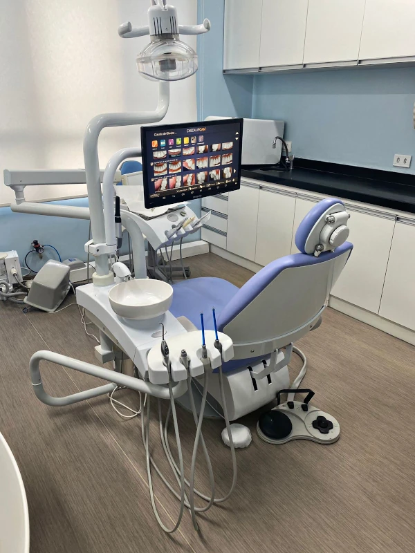 Fotografia de consultório odontológico com mesa e cadeira de dentista.